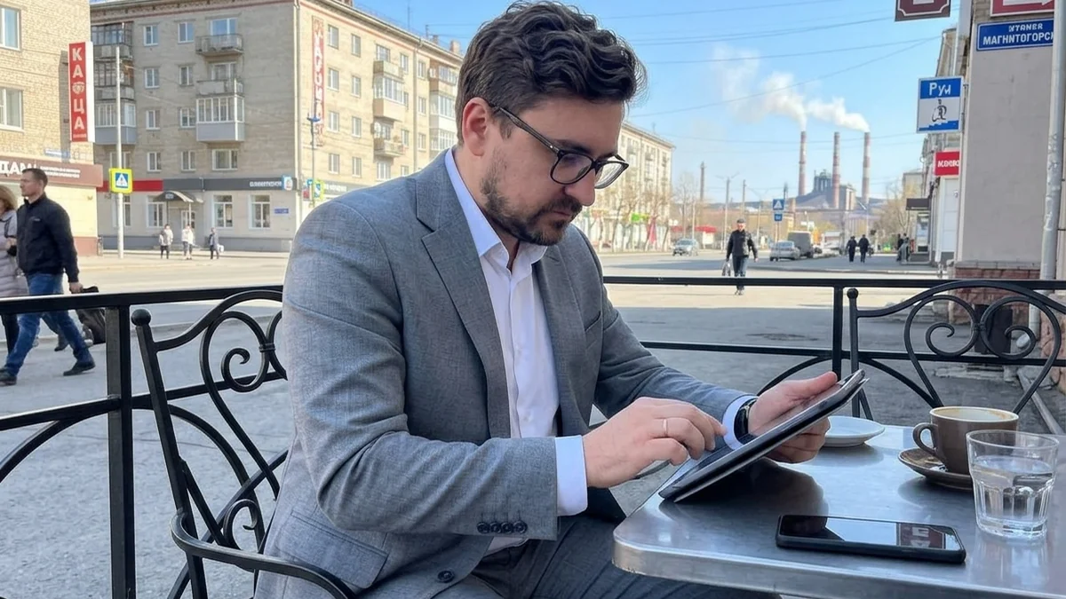 Мужчина внимательно изучает информацию на планшете