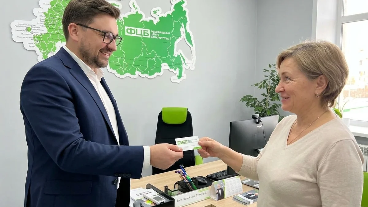 Мужчина беседует с пожилой посетительницей офиса
